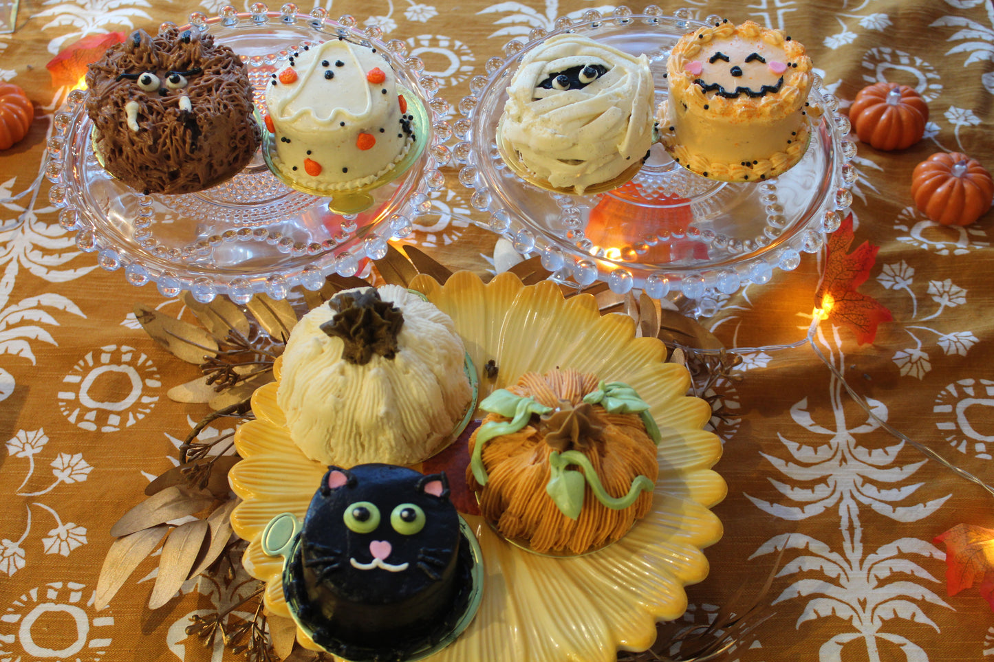 white pumpkin, orange pumpkin, black cat, jack-o-lantern and mummy, ghost and werewolf mini cakes