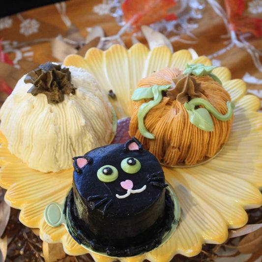 three cakes decorated as a white pumpkin, orange pumpkin and black cat for halloween decor