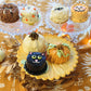 white pumpkin, orange pumpkin, black cat, jack-o-lantern and mummy, ghost and werewolf mini cakes